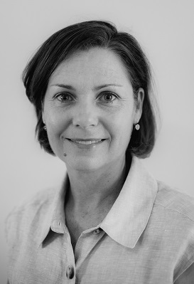 A close-up portrait of Rowena Finnane who has a short hairstyle and is looking and smiling at the camera.
