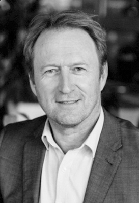 A close-up black and white portrait of Cameron Wilson