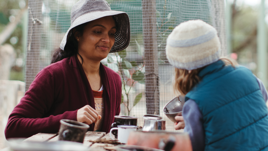 Teacher watching toddler in outdoor setting