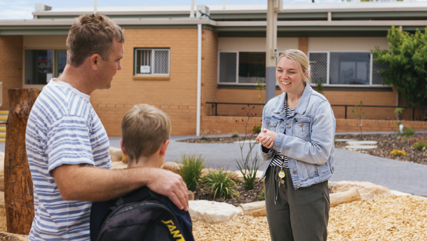 Female teacher talking to father and son 