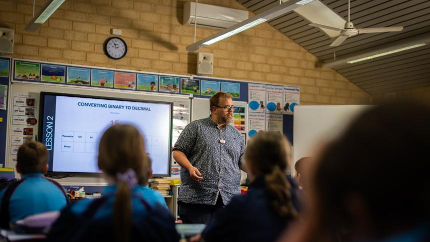 Teacher standing talking to class of students