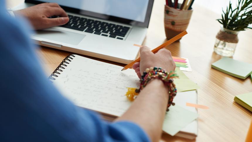 person using a laptop and notebook
