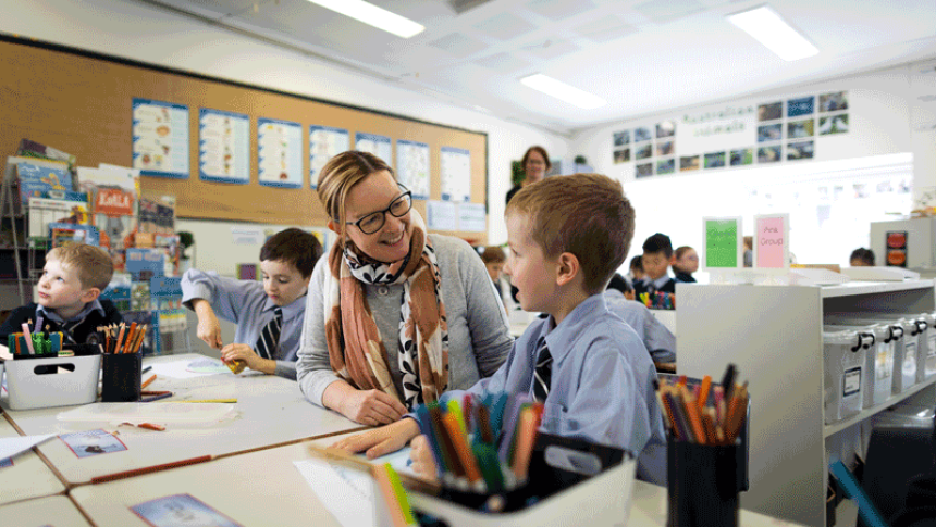 A teacher sits with a student