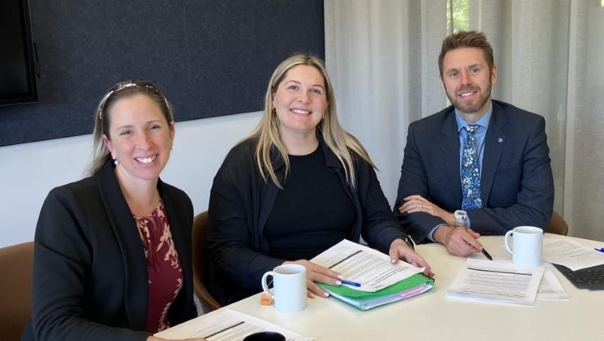 Three staff from John XXIII College sitting at a conference table